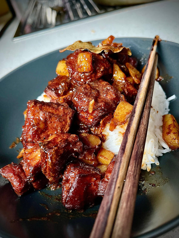 BBQ Pork Adobo in a black dish with rice and chopsticks